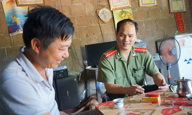 Đại úy Sằn A Phật trao đổi tình hình an ninh trật tự bằng tiếng Pạc Và với anh Trìu A Nhì, trưởng thôn Cống To, xã Tiên Lãng