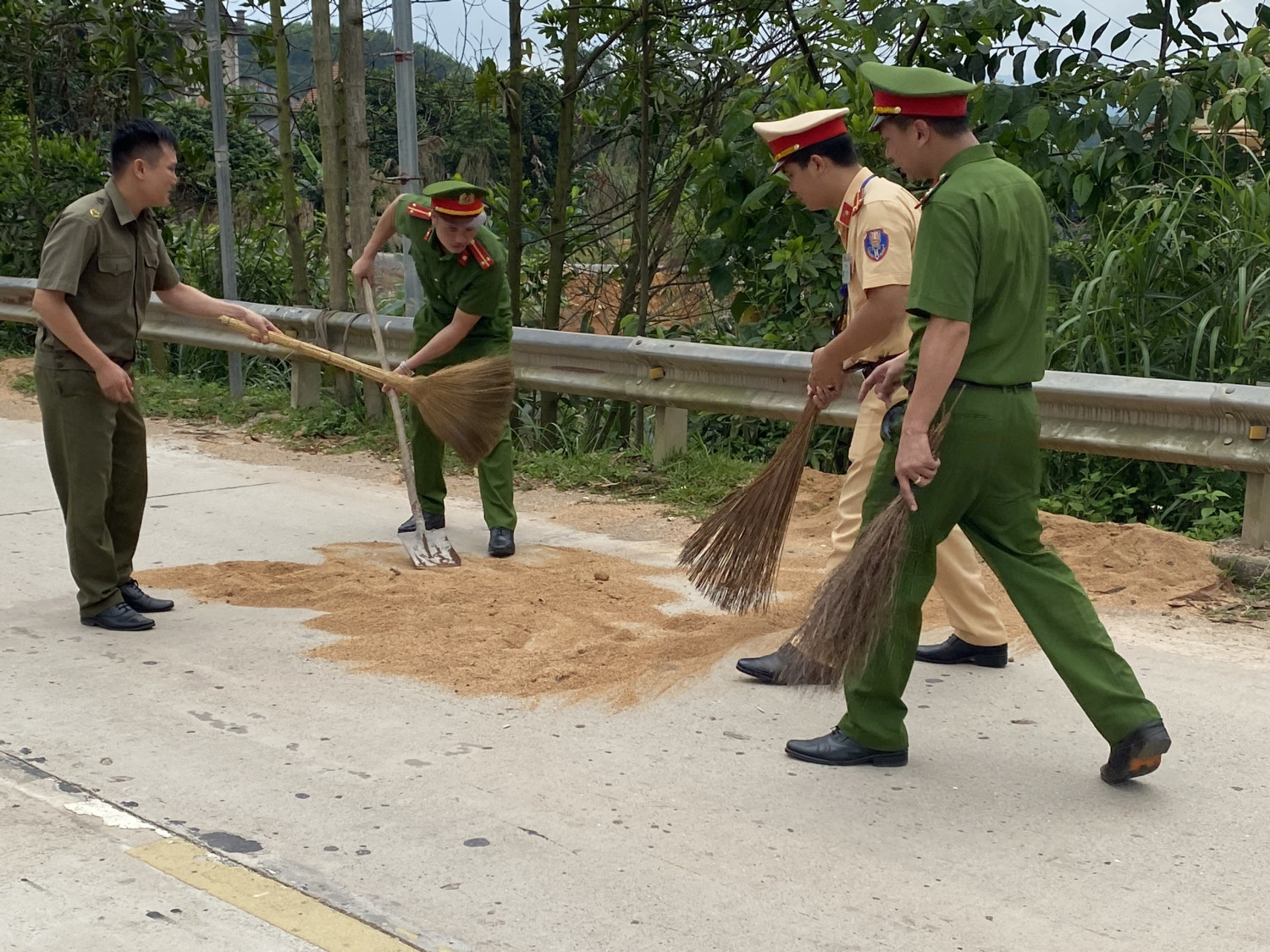 Các chiến sĩ dọn dẹp rác nhằm đảm bảo ATGT cho các phương tiện đi lại