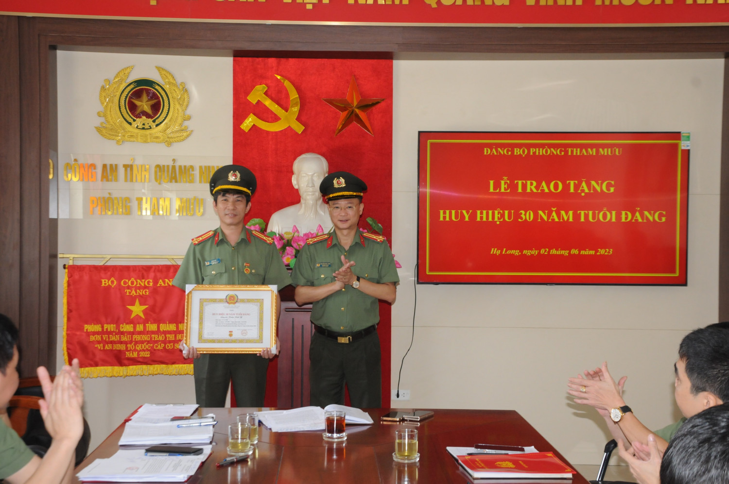 Đồng chí Nguyễn Đức Long, Bí thư Đảng ủy, Trưởng phòng Tham mưu trao Huy hiệu 30 năm tuổi đảng cho đồng chí Trần Việt Y