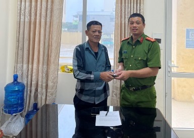 Cán bộ đội Điều tra tổng hợp Công an huyện Cô Tô tiếp nhận số tiền do anh Nguyễn Mộng Điệp giao nộp