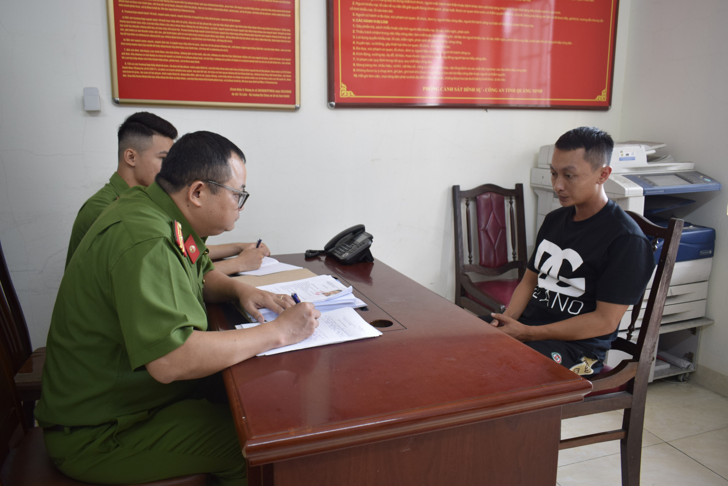 Cán bộ điều tra lấy lời khai đối tượng Nguyễn Quang Kiên